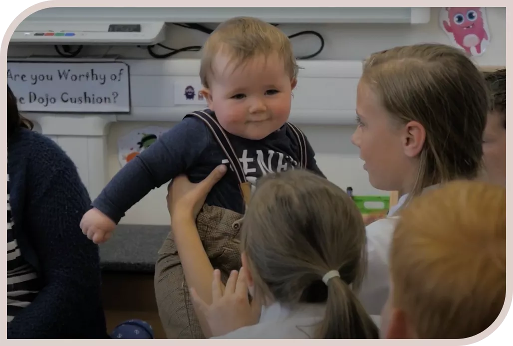 Young boy being held by students